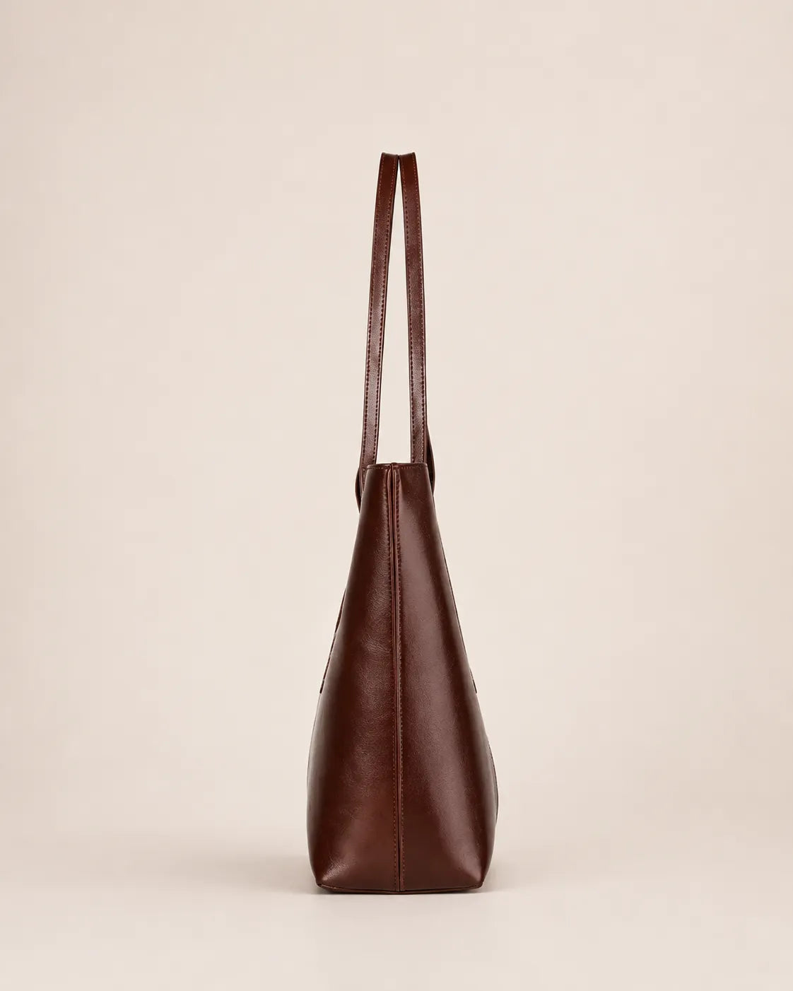 Margaux large leather tote bag side view showing structured depth and slim profile design