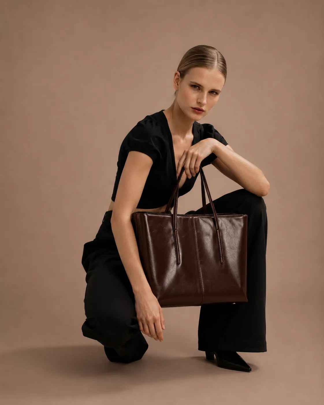 Model holding the Margaux dark chocolate leather tote bag styled for work, commuting and everyday city wear