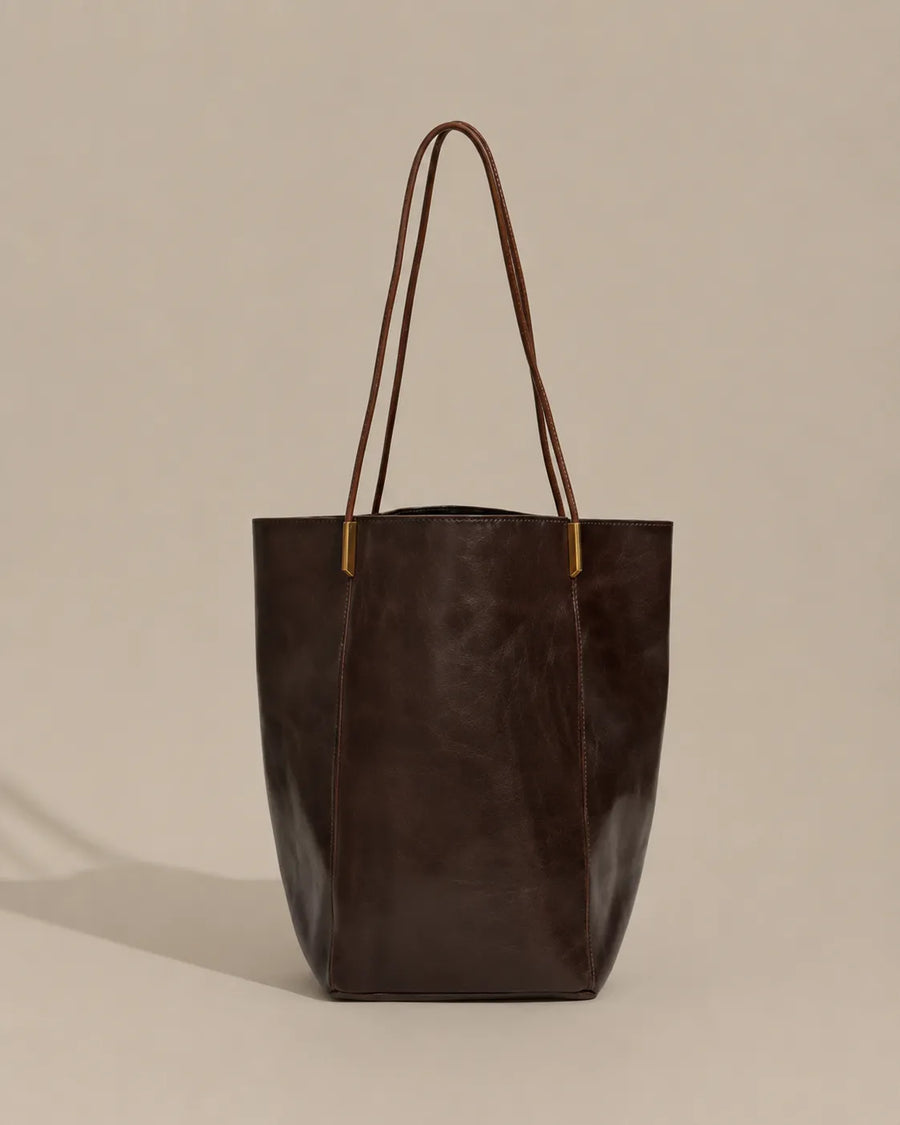 Angled front view of the Margot Tote in dark chocolate genuine leather, highlighting its elegant proportions, refined silhouette and minimalist aesthetic.