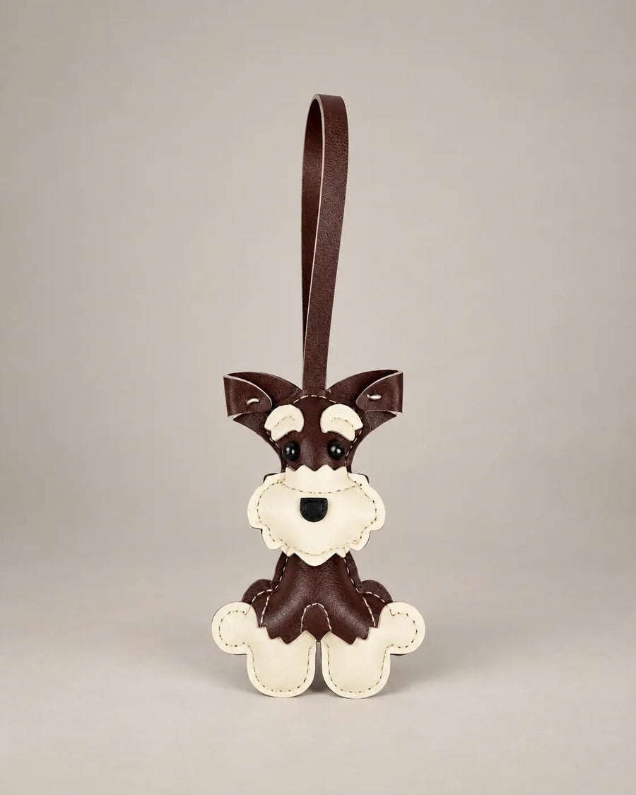 Schnauzer dog bag charm in dark brown PU leather with a cream face and paws, stitched details and a hanging loop strap, by Malena London