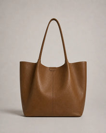 Front view of the Valentina Tote in brown leather featuring a minimalist silhouette, soft structure and generous capacity.