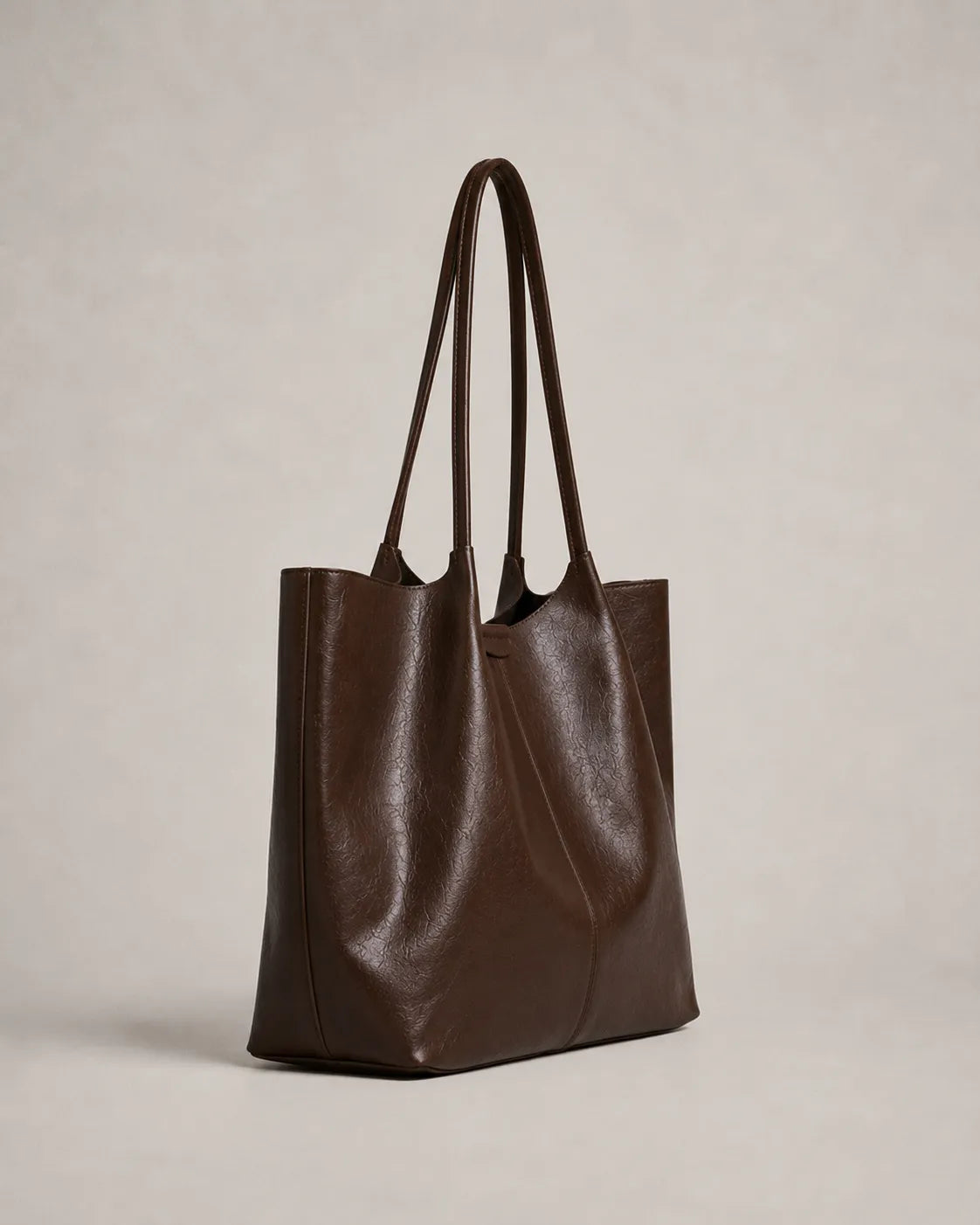 Angled view of the Valentina Tote in dark chocolate leather highlighting its soft structure, generous capacity and refined proportions.