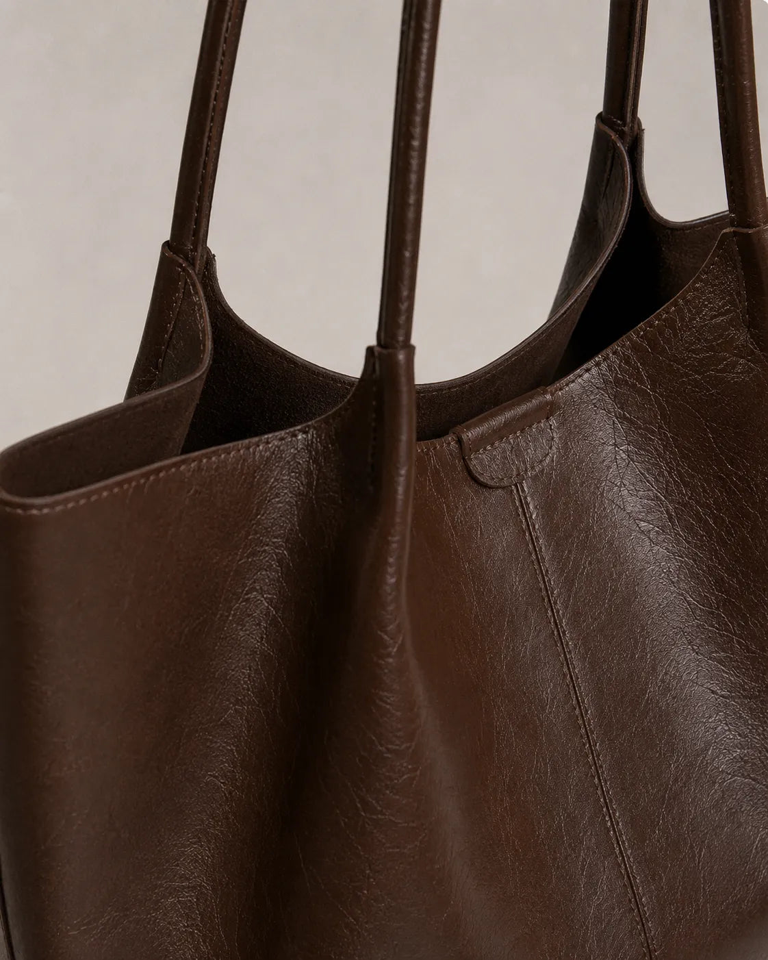 Close-up detail of the Valentina Tote in dark chocolate leather showcasing the soft texture, refined stitching and elegant shoulder straps.