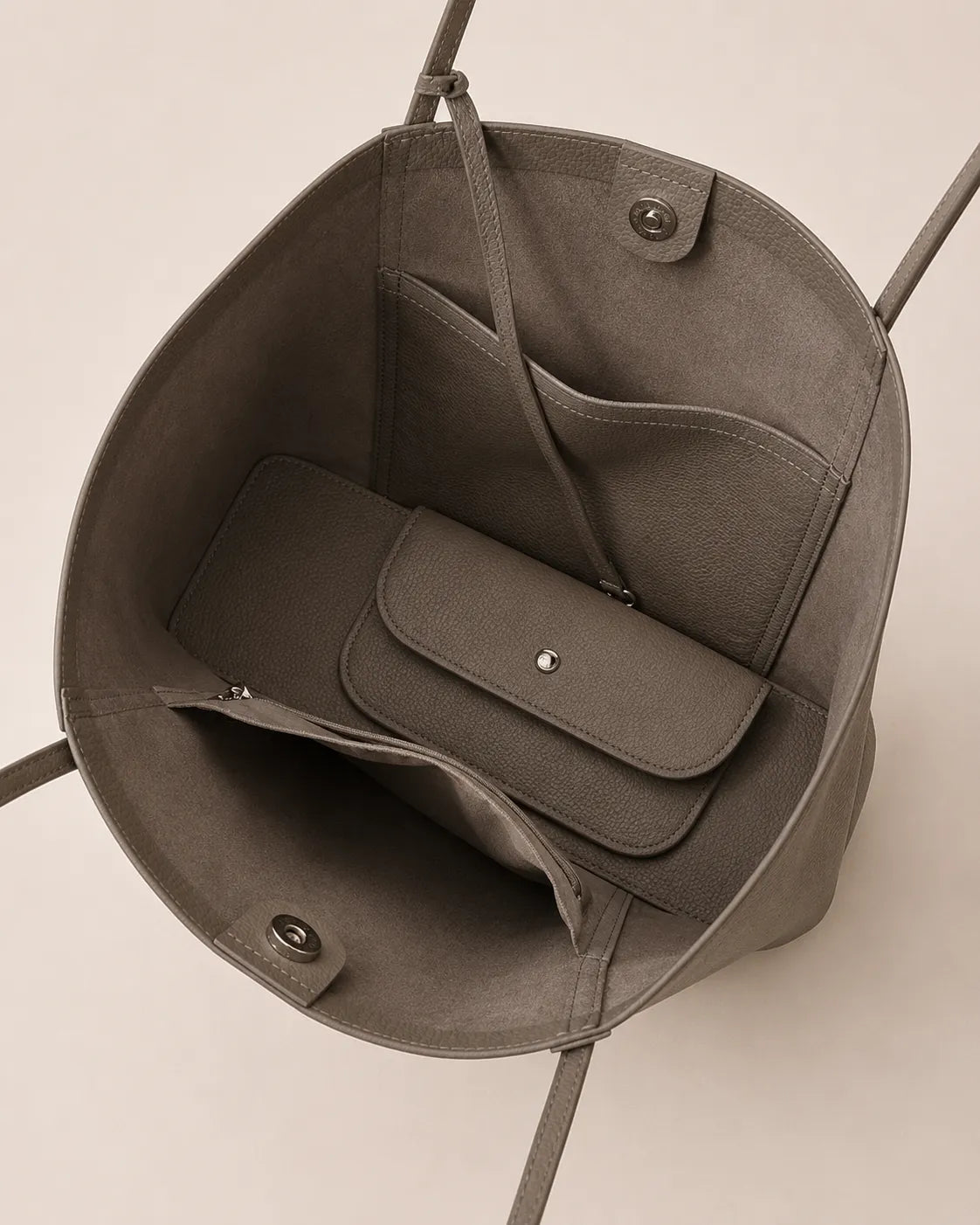 Interior view of the Vivienne large Togo leather tote bag in elephant grey featuring an open compartment, magnetic closure, slip pockets and matching detachable coin pouch.