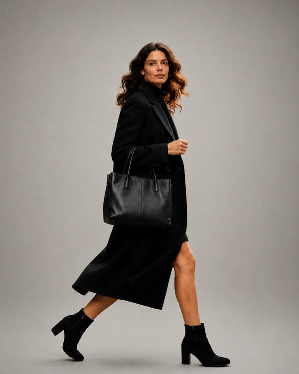 Woman carrying a premium black leather work tote bag designed for commuting, office days and modern city living by Malena London