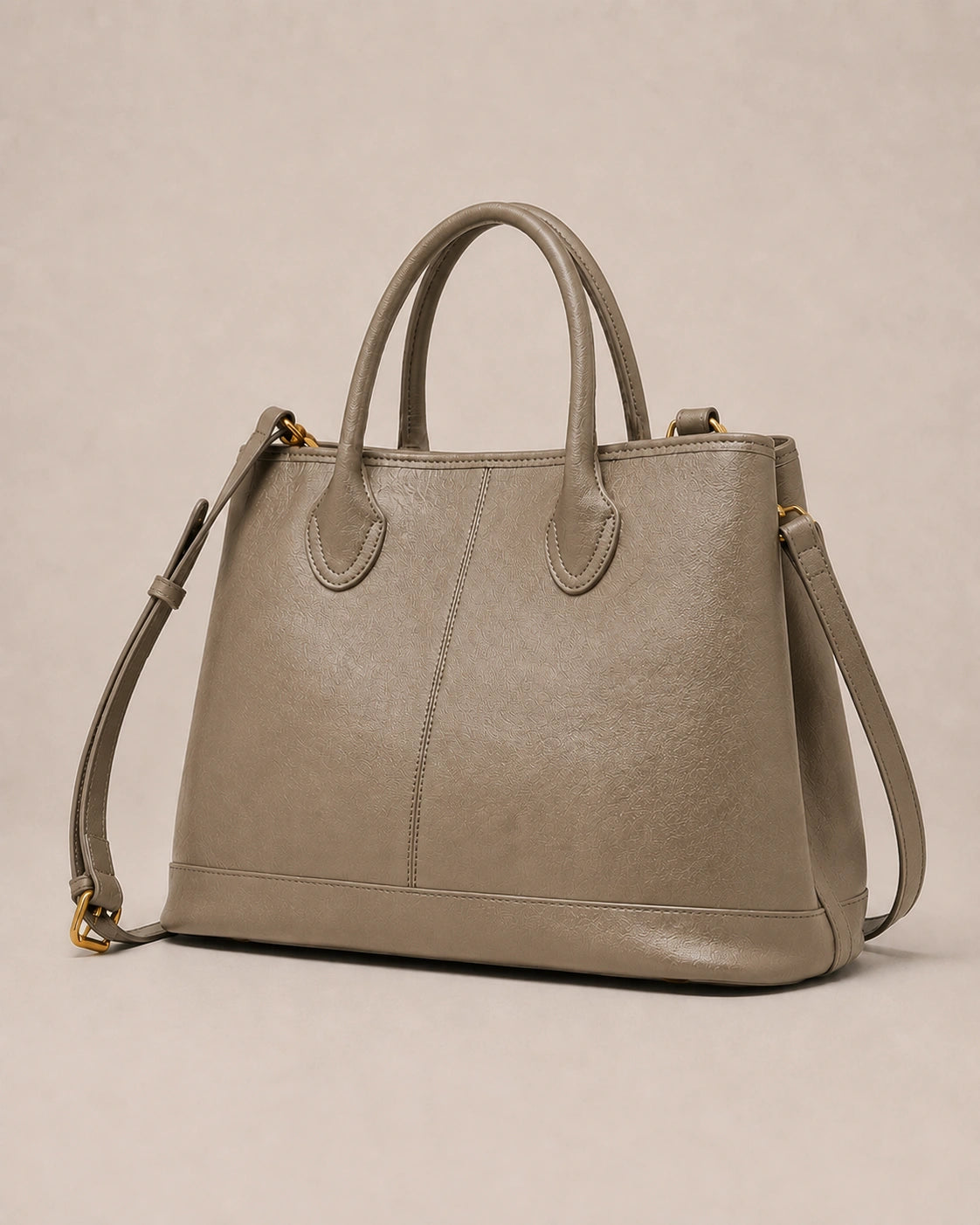 Angled view of the Odile large structured genuine leather tote bag in grey with the crossbody strap laid out.