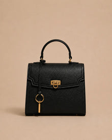 Beatrice genuine leather top handle bag in black featuring structured silhouette, gold-tone hardware, front lock closure and detachable shoulder strap. The Essentials Collection by Malena London.