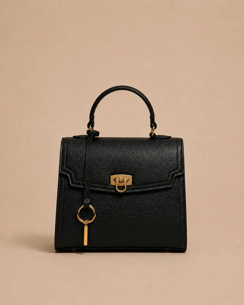 Beatrice genuine leather top handle bag in black featuring structured silhouette, gold-tone hardware, front lock closure and detachable shoulder strap. The Essentials Collection by Malena London.