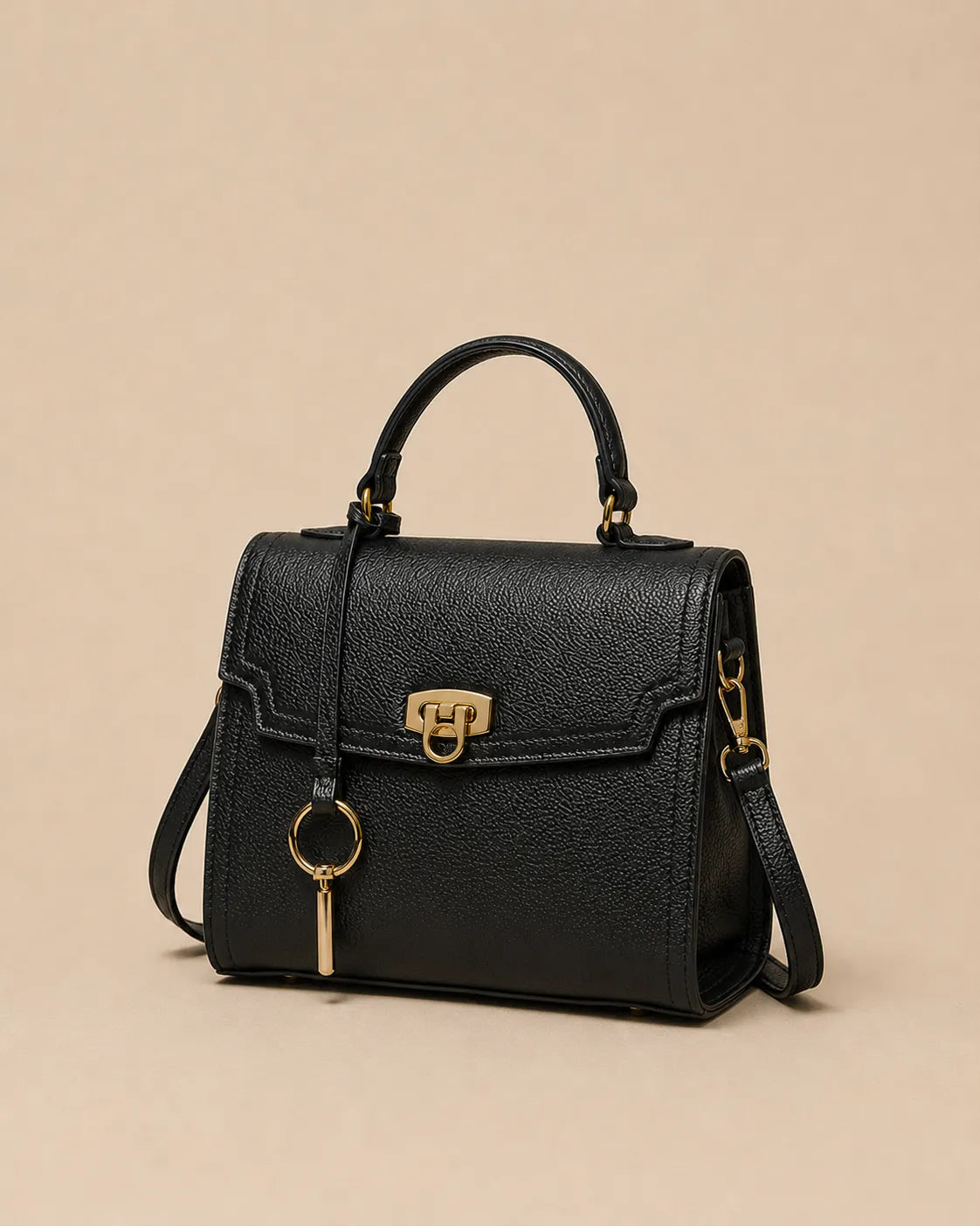 Beatrice genuine leather top handle bag in black featuring a structured silhouette, gold-tone hardware, detachable shoulder strap and elegant three-quarter front view. The Essentials Collection by Malena London.