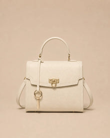 Beatrice genuine leather top handle bag in rice white featuring a structured silhouette, premium pebbled leather, gold-tone lock closure and detachable shoulder strap. The Essentials Collection by Malena London.