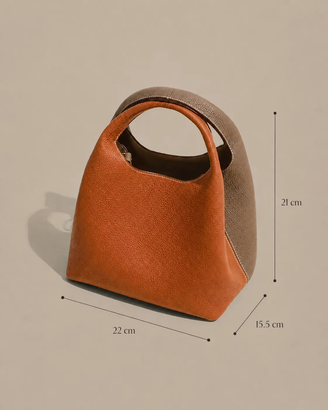 Dimensions of the Camille architectural leather bucket bag measuring 22 cm wide, 21 cm high and 15.5 cm deep.
