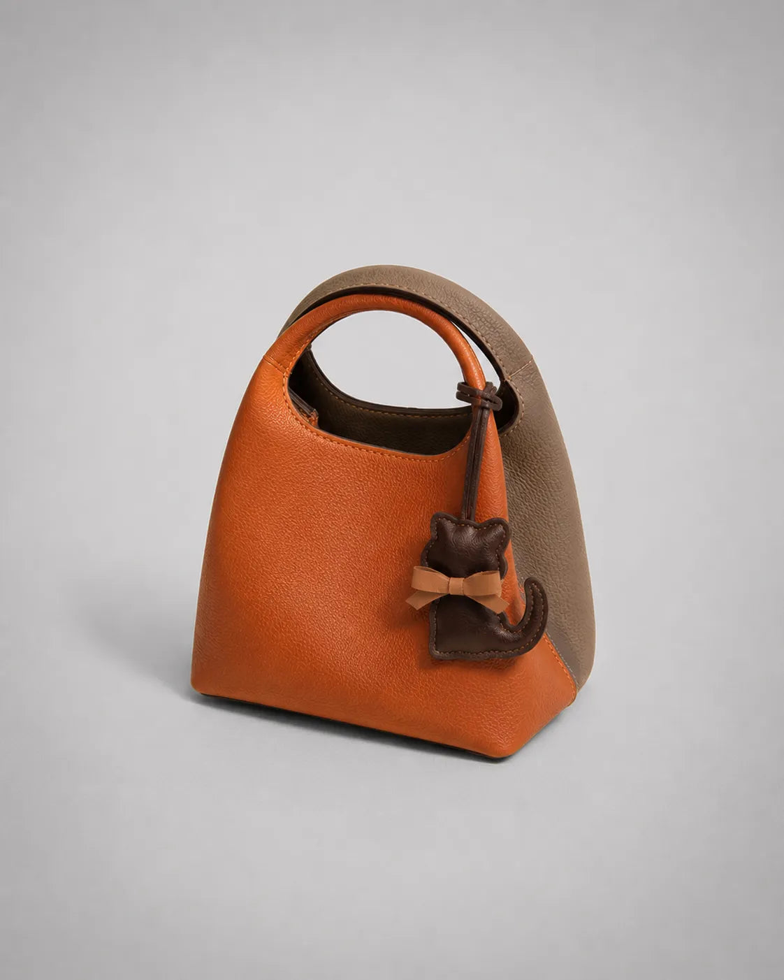 Dark chocolate cat bag charm styled on a modern handbag, showcasing a playful accessory designed to personalise handbags and elevate everyday styling.