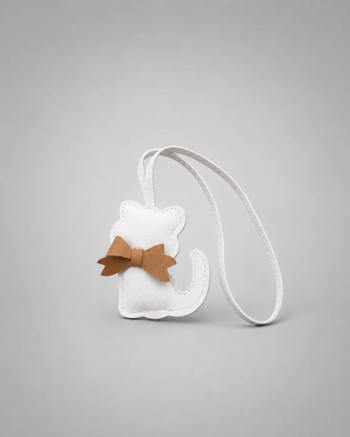White cat bag charm with bow detail displayed on a clean studio background, designed to personalise handbags and accessories.