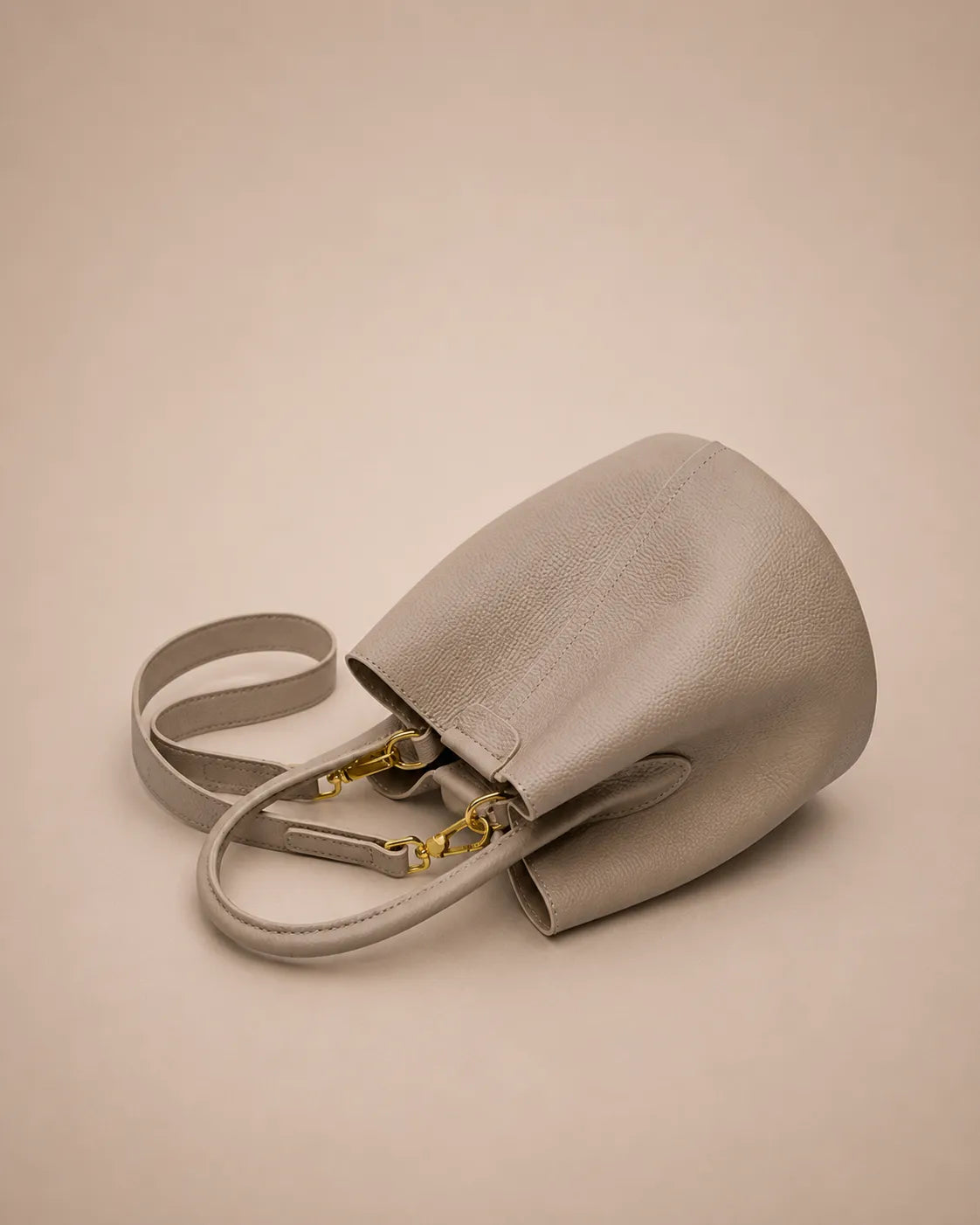 Bottom view of the Charlotte leather bucket bag in elephant gray showcasing premium genuine leather craftsmanship and soft construction.