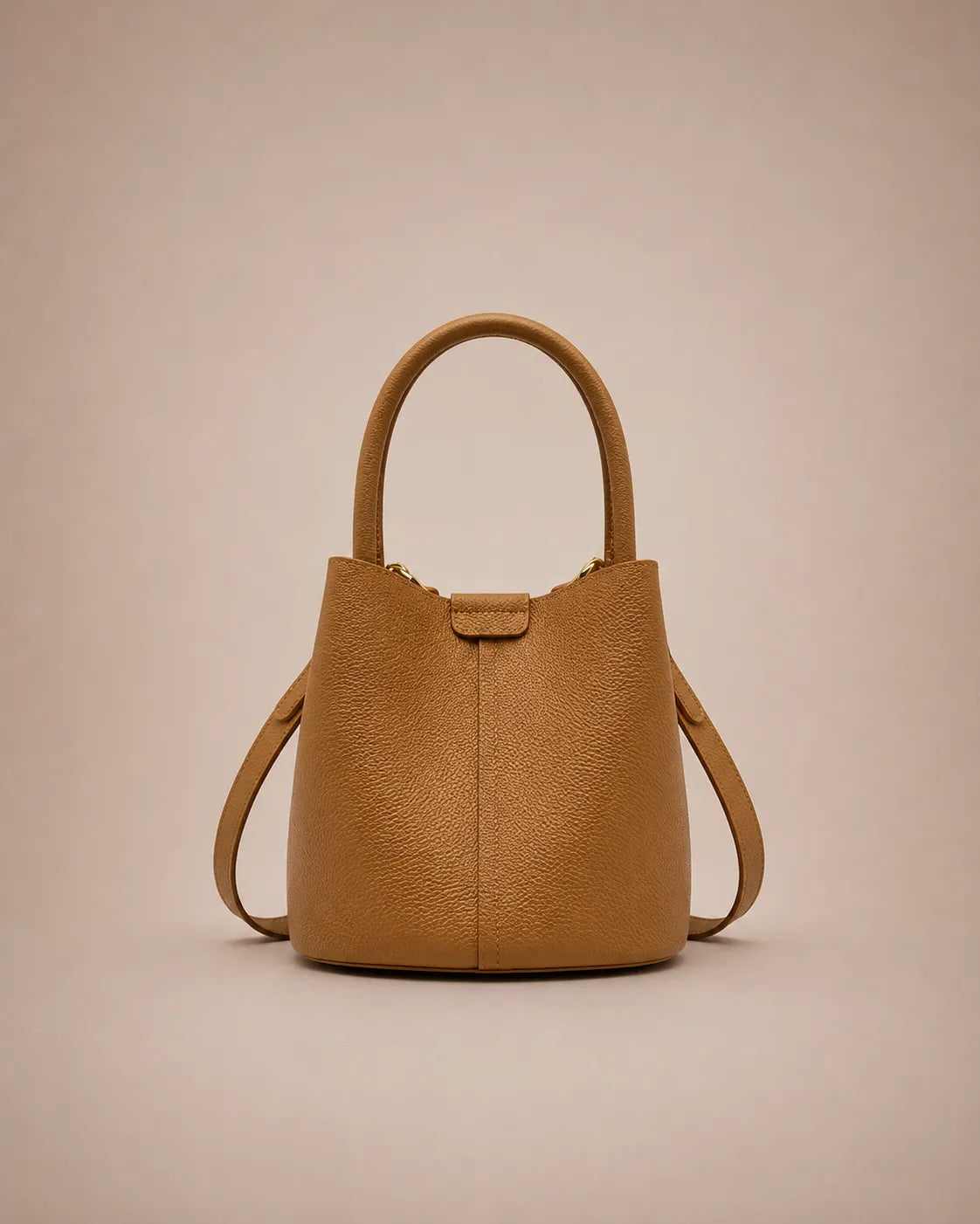 Charlotte genuine leather bucket bag in cookie brown featuring a timeless silhouette, top handle and adjustable shoulder strap.
