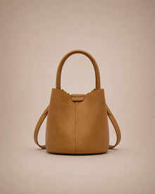 Charlotte genuine leather bucket bag in cookie brown featuring a timeless silhouette, top handle and adjustable shoulder strap.