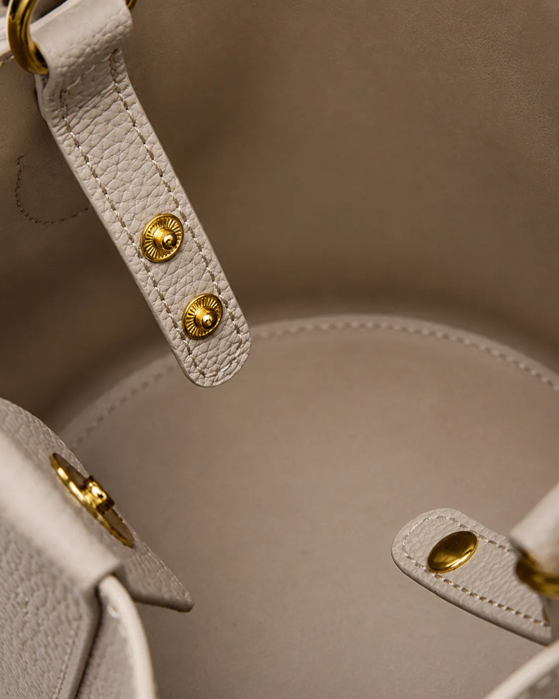 Interior detail of the Charlotte leather bucket bag in elephant gray showcasing premium leather lining, secure fastening and refined craftsmanship.