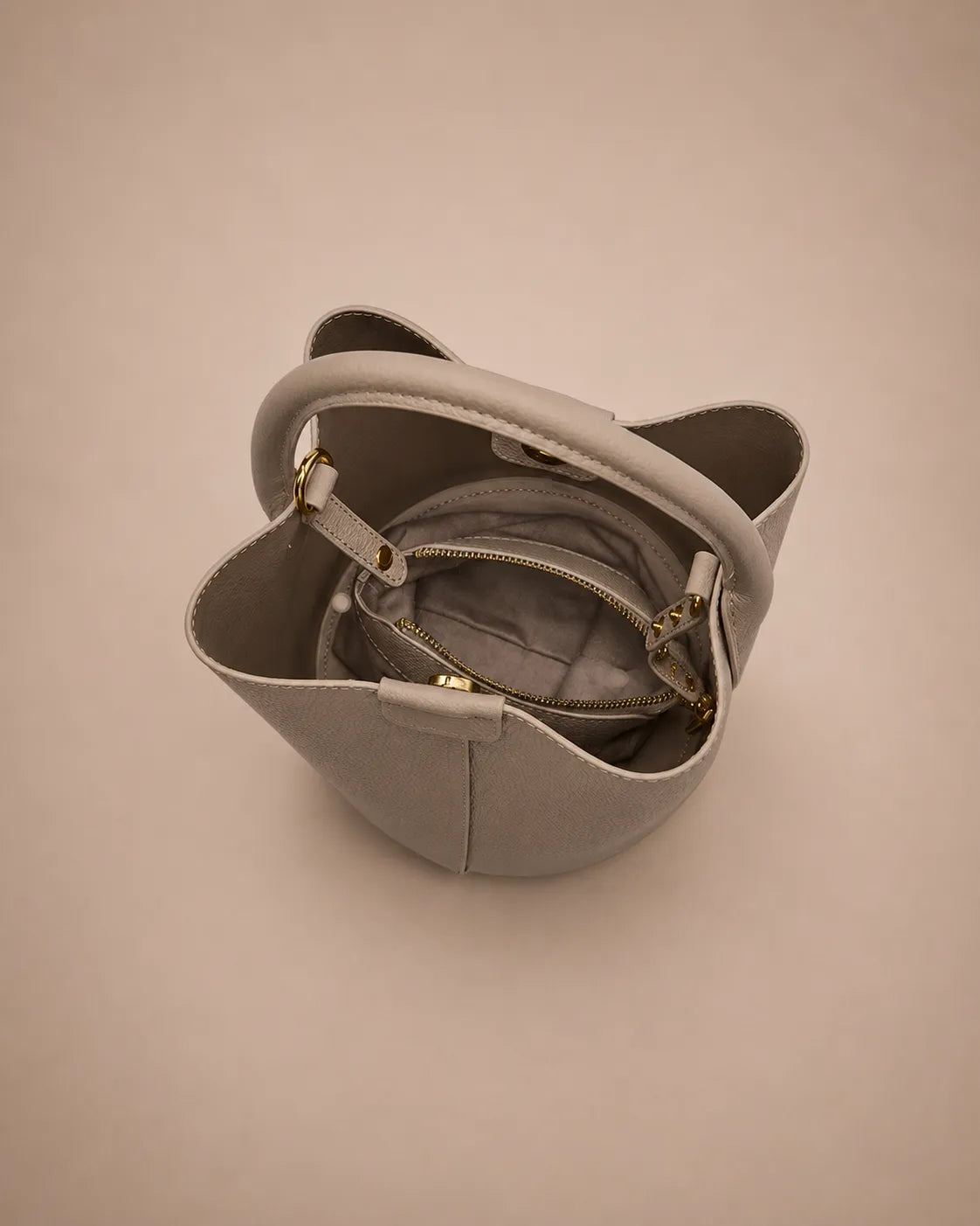 Top view of the Charlotte leather bucket bag in elephant gray featuring an organized interior, zip compartment and practical everyday storage.