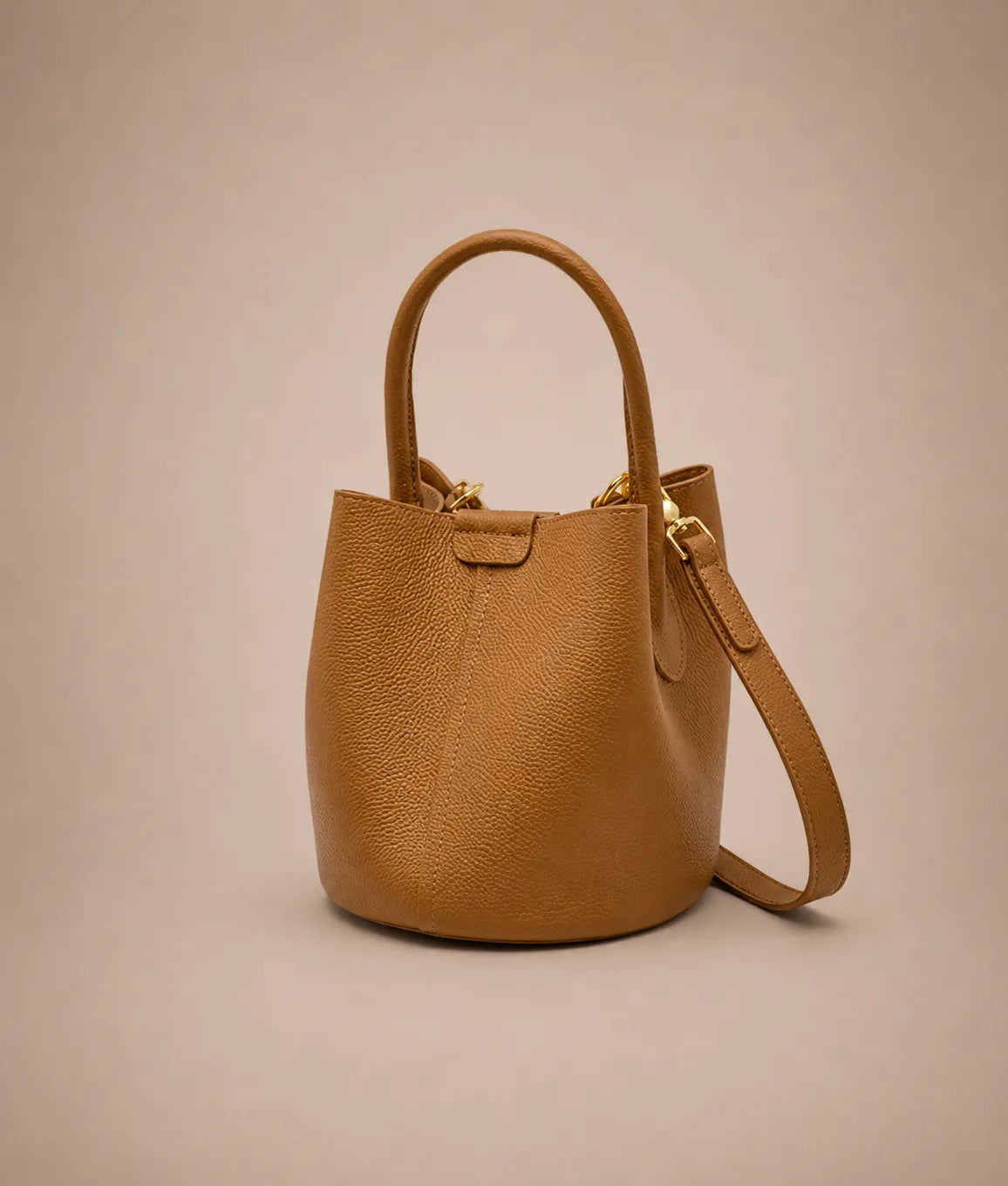 Side view of the Charlotte leather bucket bag in cookie brown highlighting its elegant bucket silhouette and structured everyday design.