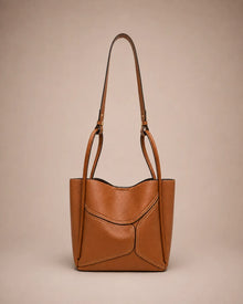 Delphine Leather Shoulder Bag in Cookie genuine leather featuring an architectural front panel design, structured silhouette, top handles and removable shoulder strap. A statement leather handbag by Malena London.