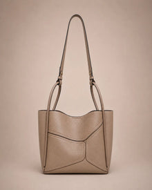 Delphine Leather Shoulder Bag in Elephant Gray genuine leather featuring an architectural front panel design, structured silhouette, top handles and removable 60 cm shoulder strap. A modern statement handbag by Malena London.