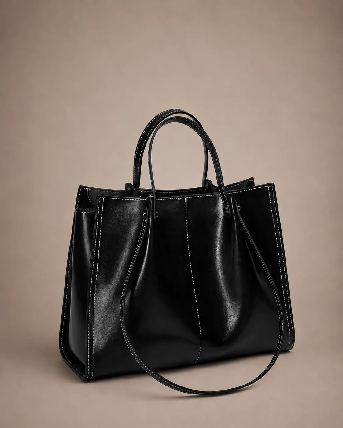 Angled front view of the Edith Leather Tote Bag in Black genuine leather, highlighting its structured shape, elegant handles and spacious design from The City Edit collection by Malena London.