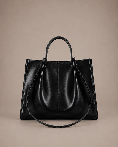 Edith Leather Tote Bag in Black genuine leather shown from the front, featuring a structured silhouette, contrast stitching and elegant top handles from The City Edit collection by Malena London.