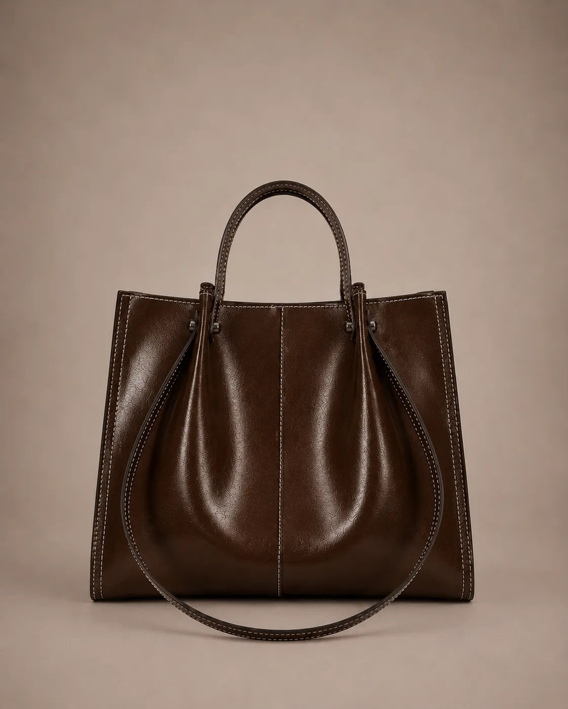 Edith Leather Tote Bag in Dark Chocolate genuine leather shown from the front, featuring a structured silhouette, contrast stitching and elegant top handles from The City Edit collection by Malena London.