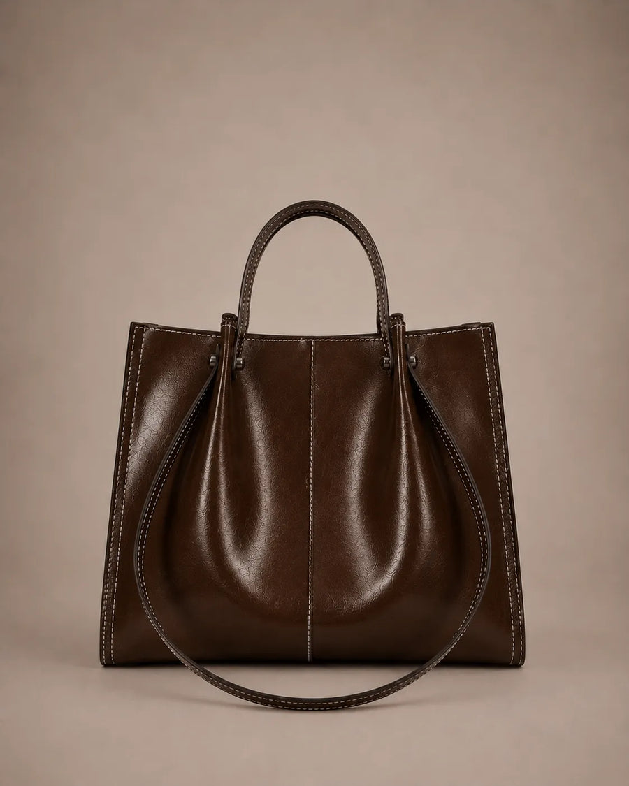Edith Leather Tote Bag in Dark Chocolate genuine leather shown from the front, featuring a structured silhouette, contrast stitching and elegant top handles from The City Edit collection by Malena London.