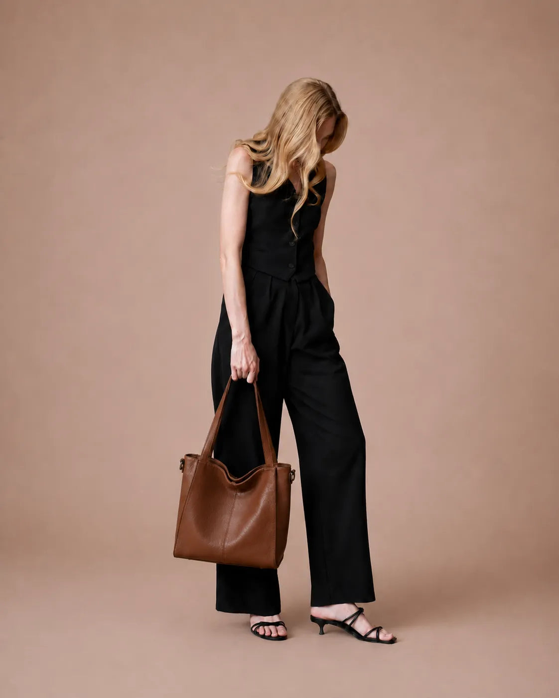 Woman carrying The Eleanor Brown everyday leather tote bag. Spacious genuine leather handbag created for work, commuting and effortless daily elegance.
