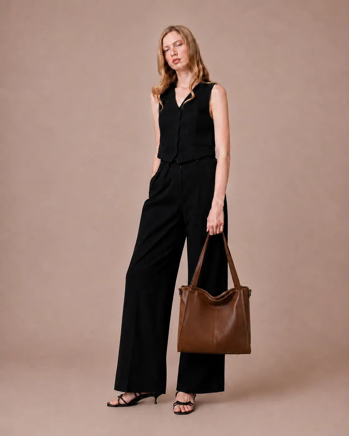 The Eleanor Brown women's leather tote bag showcased by model. Structured genuine leather work bag with a timeless silhouette for office and everyday use.