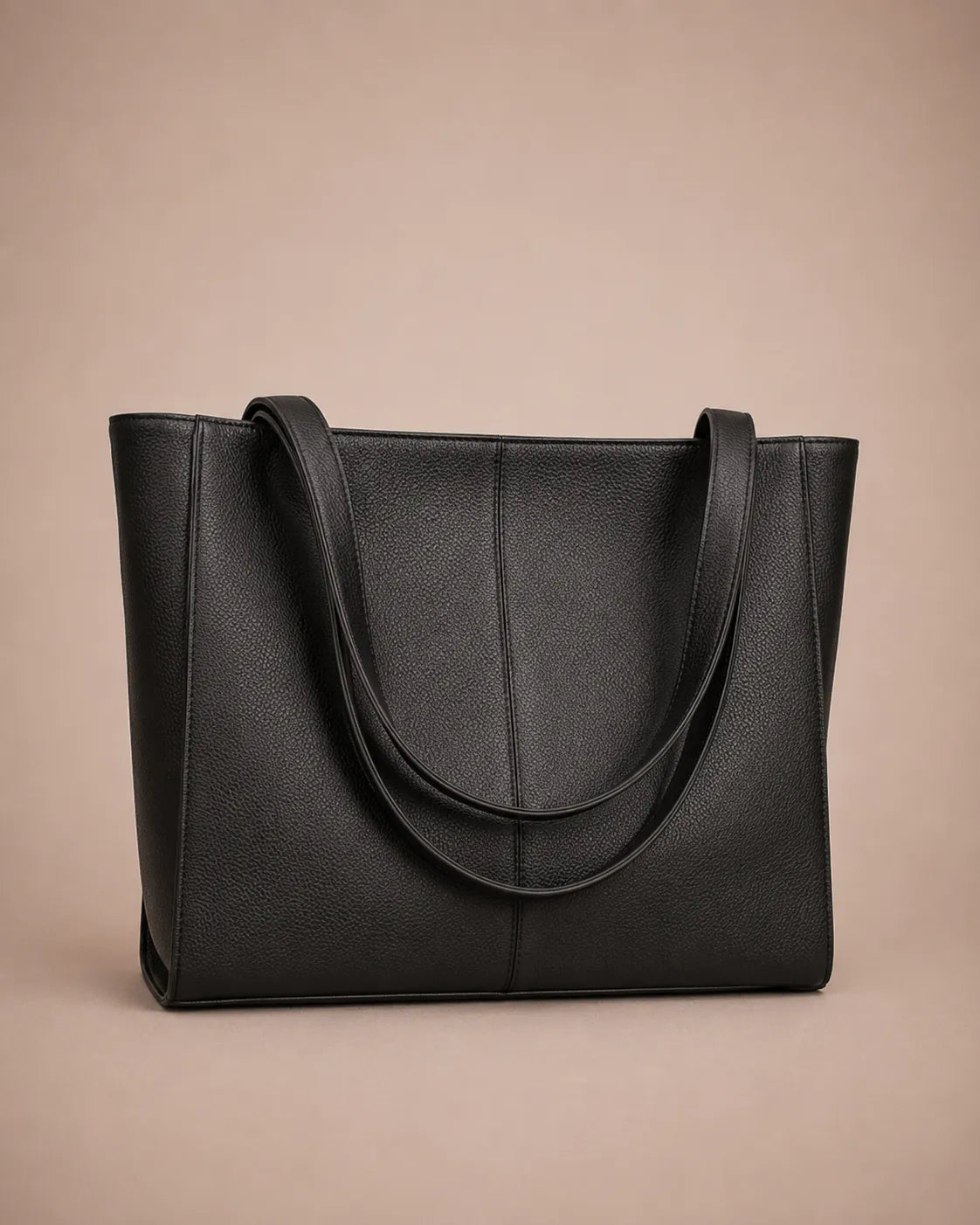 Three-quarter view of the Eleanor genuine leather tote bag in Black featuring a structured silhouette, long shoulder straps, spacious interior capacity and minimalist design. Premium women's leather work tote from The City Edit collection by Malena London.