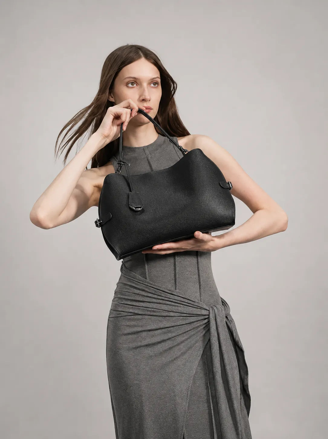 Woman wearing The Eliza black leather bag as a crossbody style. Versatile leather shoulder bag for women designed for everyday elegance and day to evening wear.