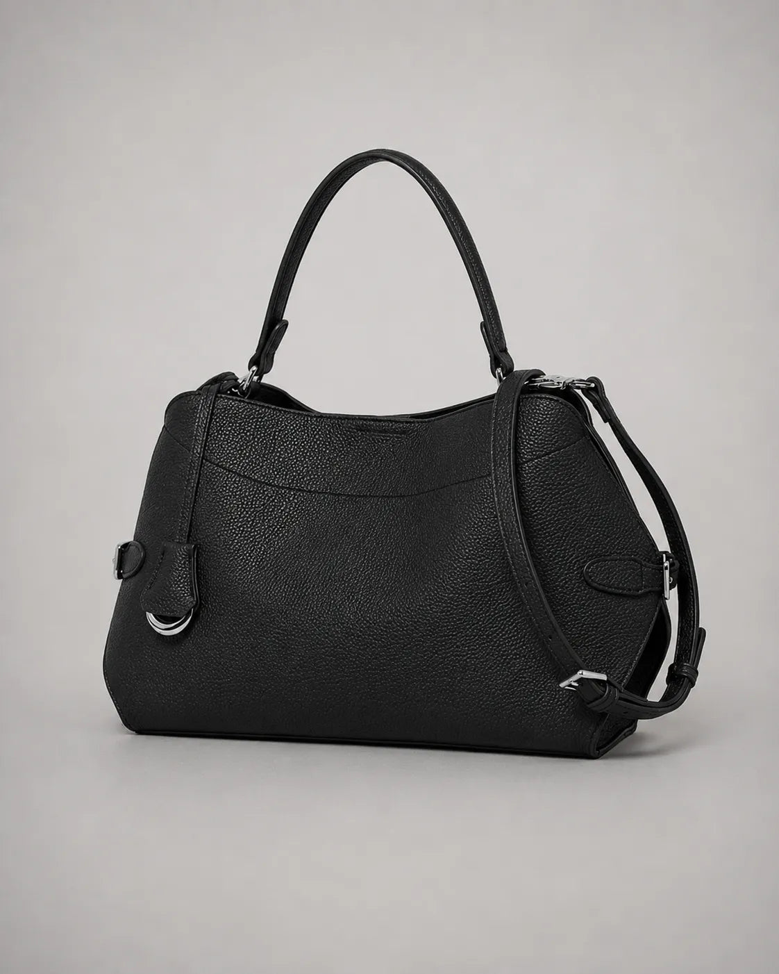 Angled view of the Eliza genuine leather shoulder bag in Black highlighting the curved silhouette, removable shoulder strap, adjustable crossbody strap, premium pebbled leather and elegant day-to-evening styling by Malena London.