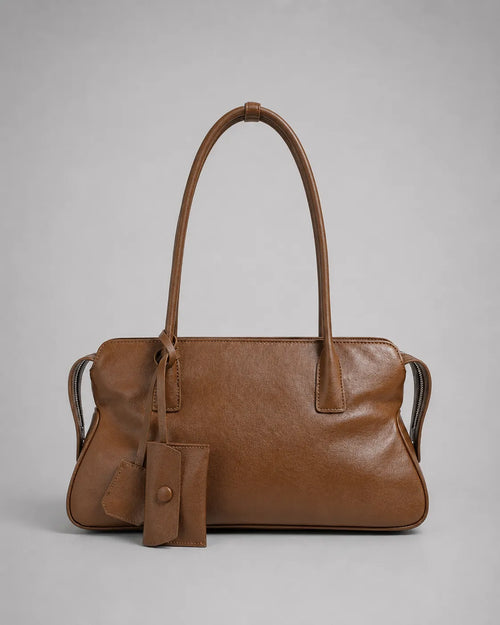 Georgia leather shoulder bag in Brown genuine leather front view featuring a soft structured silhouette, elongated shoulder straps, decorative leather charms and zip-top closure from the Soft Structure collection by Malena London.