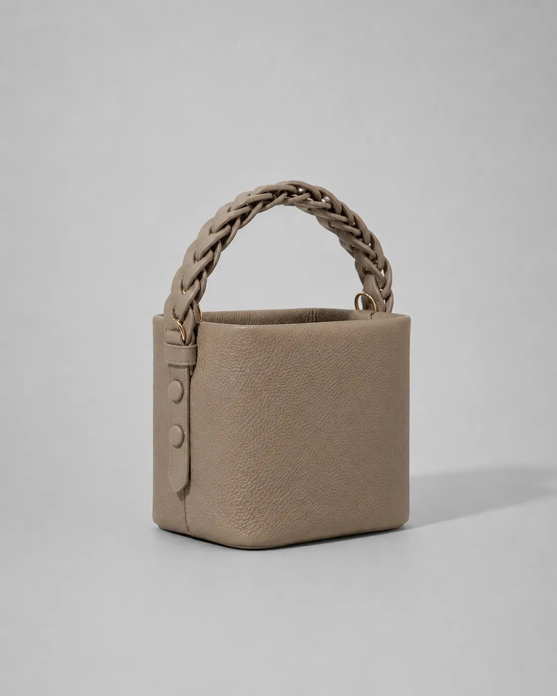 Back view of the Léonie genuine leather bucket bag in Elephant Gray showcasing the sculptural braided leather handle, clean rear panel and structured bucket silhouette by Malena London.