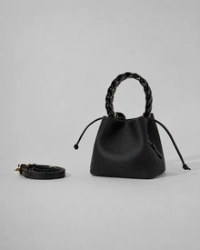 Front view of the Léonie genuine leather bucket bag in Black featuring a braided leather top handle, drawstring closure and modern statement bucket silhouette by Malena London.