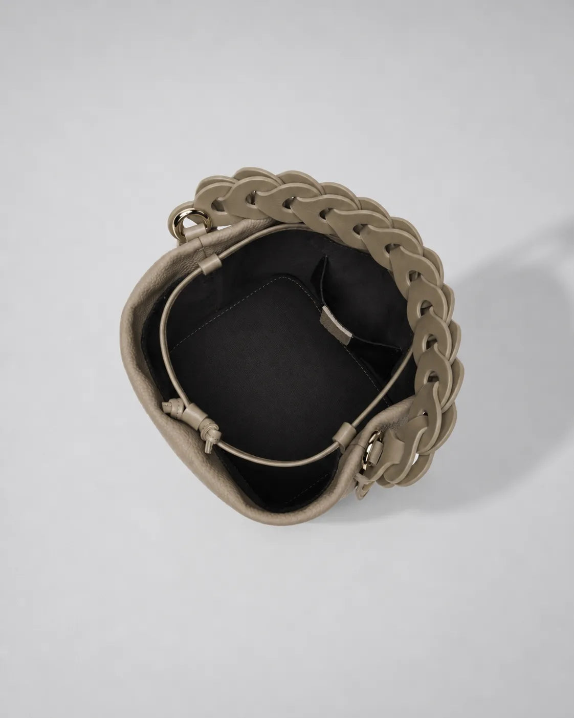 Top view of the Léonie genuine leather bucket bag in Cookie showcasing the drawstring opening, spacious interior compartment, braided leather handle and modern bucket bag construction by Malena London.