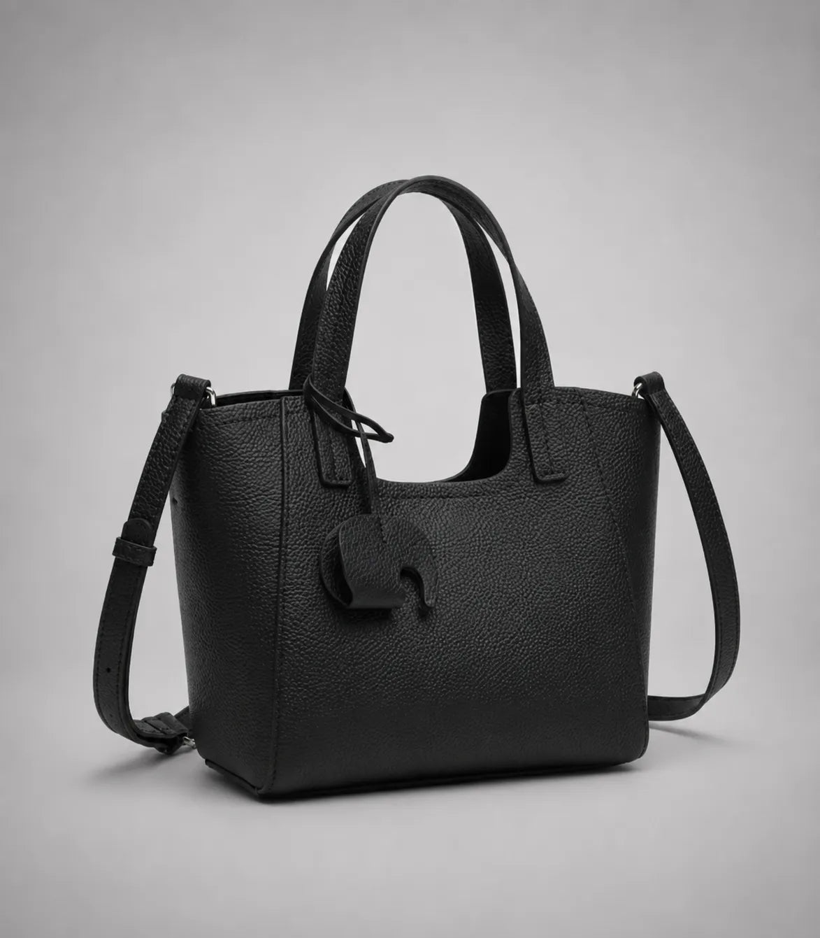 Louise genuine leather tote bag in black leather with structured design, detachable shoulder strap and signature elephant charm.