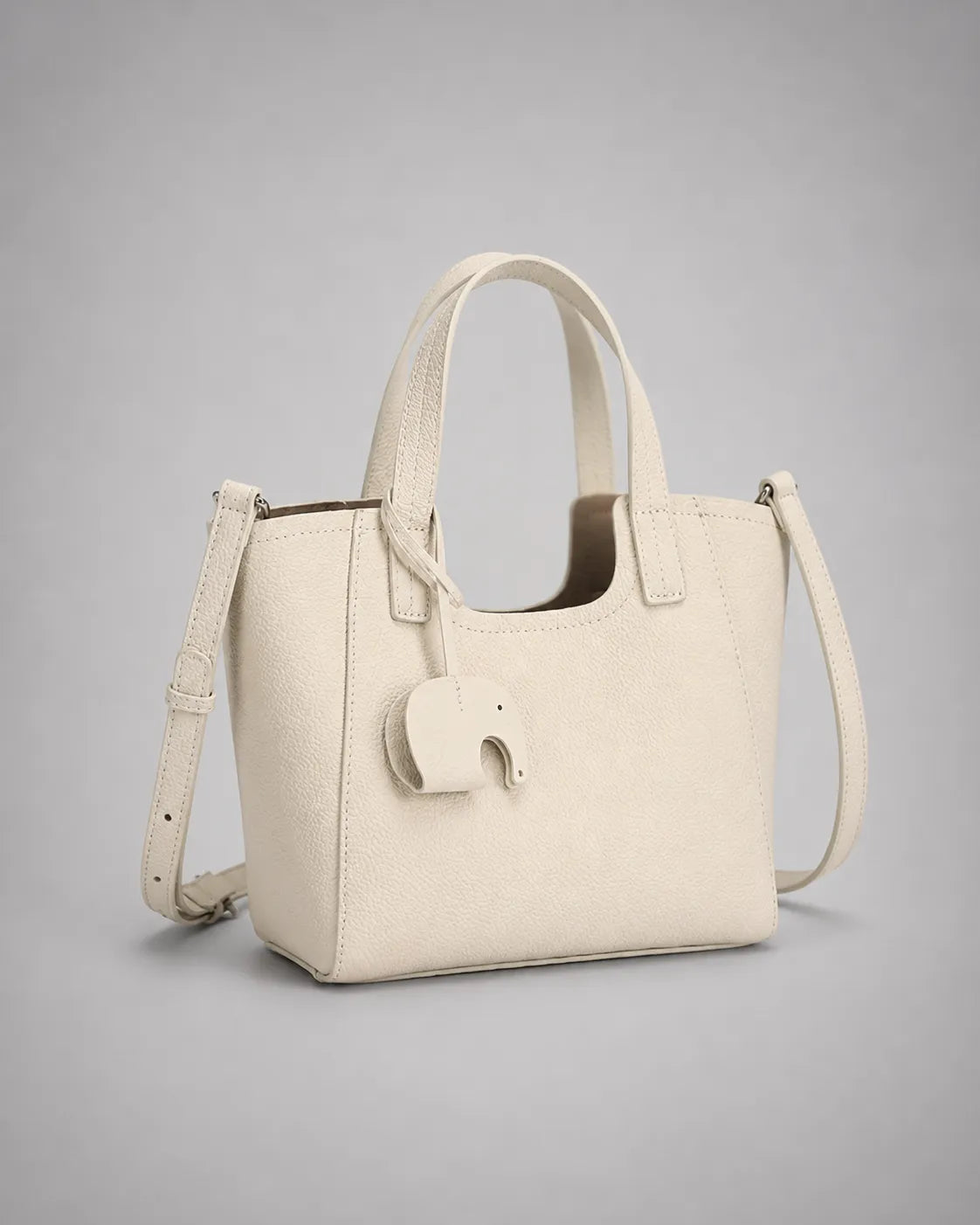 Louise genuine leather tote bag in cream white leather featuring a structured silhouette, detachable shoulder strap and signature elephant charm.