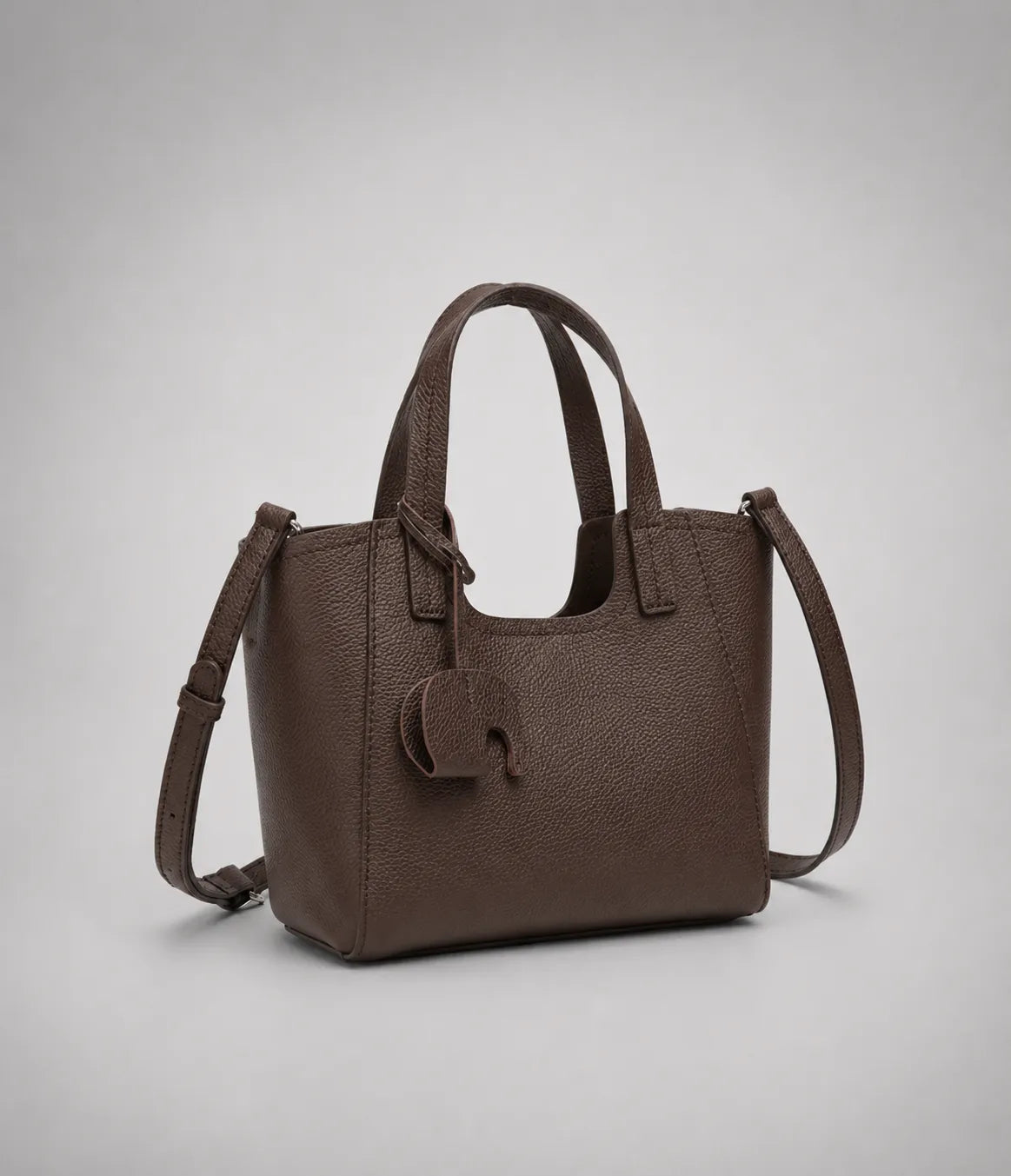 Louise genuine leather tote bag in dark chocolate leather featuring a structured silhouette, detachable shoulder strap and signature elephant charm.