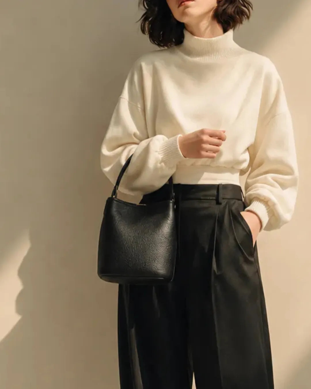 Model wearing The Bonnie genuine leather bucket shoulder bag, featuring its adjustable strap, compact silhouette, premium leather construction and effortless everyday style.