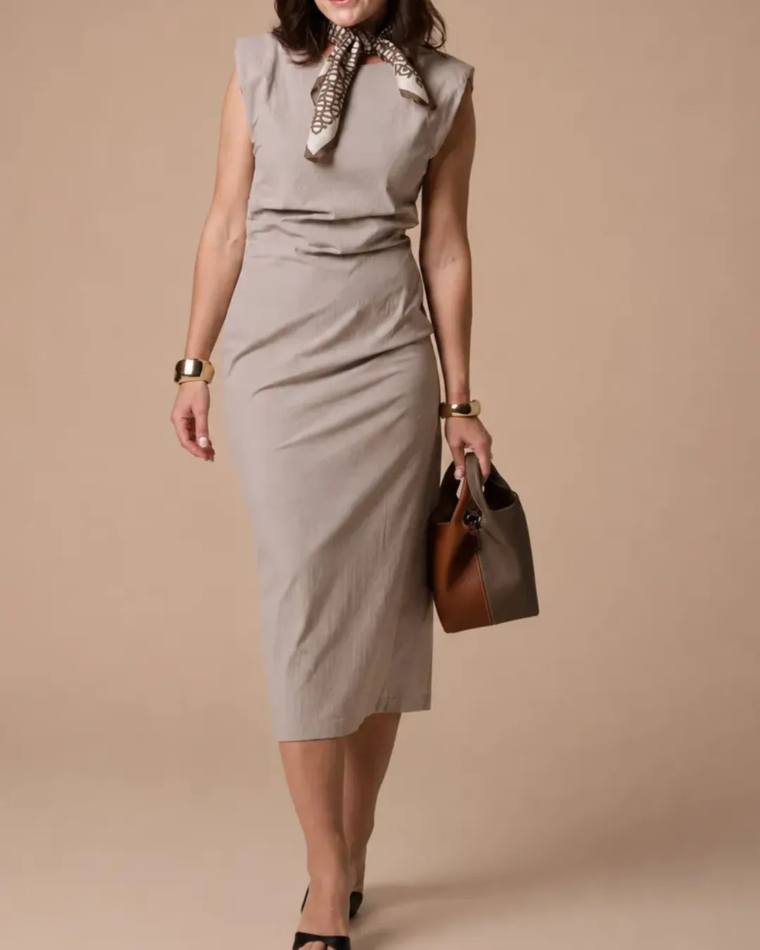 Model carrying The Camille two-tone genuine leather bucket bag by hand, showcasing its sculptural silhouette, premium first-layer leather and elegant architectural design for everyday sophistication.
