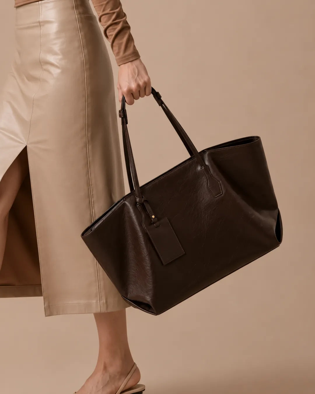 Close-up of The Emilia dark chocolate genuine leather tote bag, highlighting the premium leather texture, spacious soft structured silhouette, adjustable shoulder straps and elegant everyday craftsmanship.