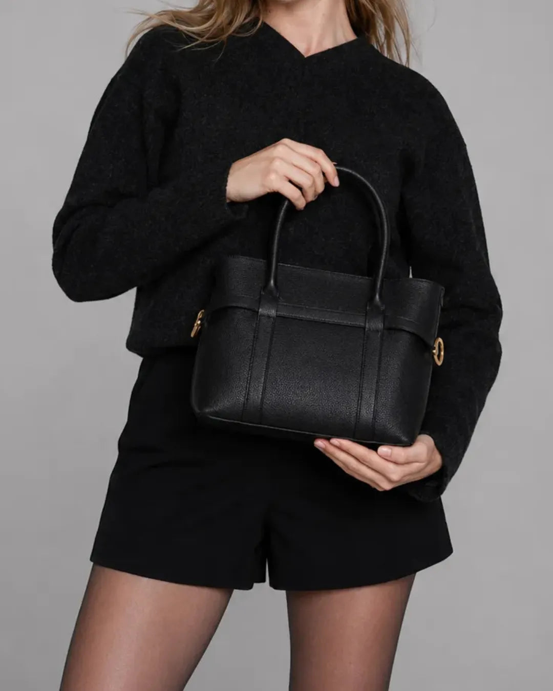 Front close-up of The Rose black genuine leather tote bag featuring premium pebbled leather, structured silhouette, elegant gold-tone hardware and spacious everyday design.