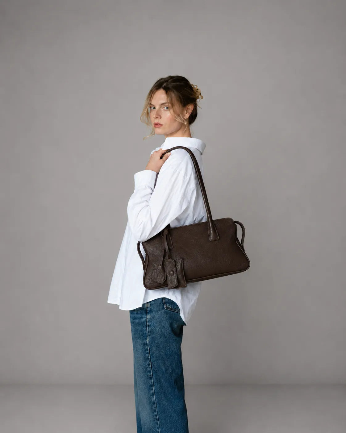 Model wearing The Georgia luxury genuine leather shoulder bag in Dark Chocolate, elegant women's leather handbag designed for everyday style and versatility.