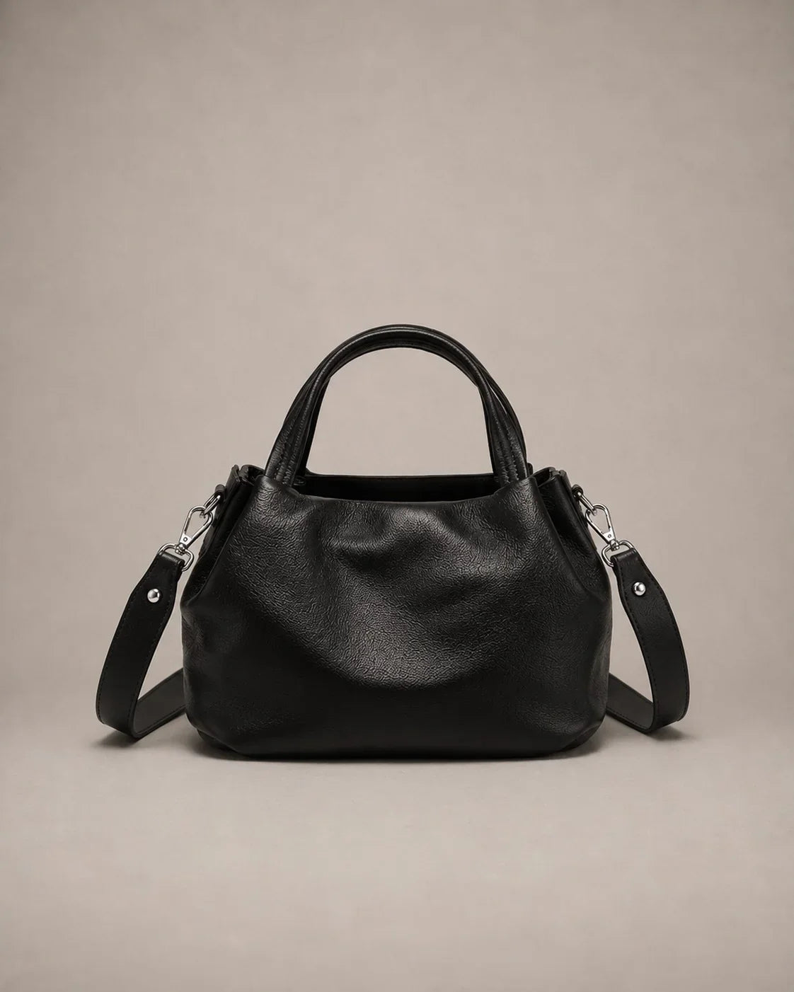Front view of the Pauline genuine leather top handle crossbody bag in Black featuring soft pebbled leather, a structured silhouette and an adjustable shoulder strap by Malena London.