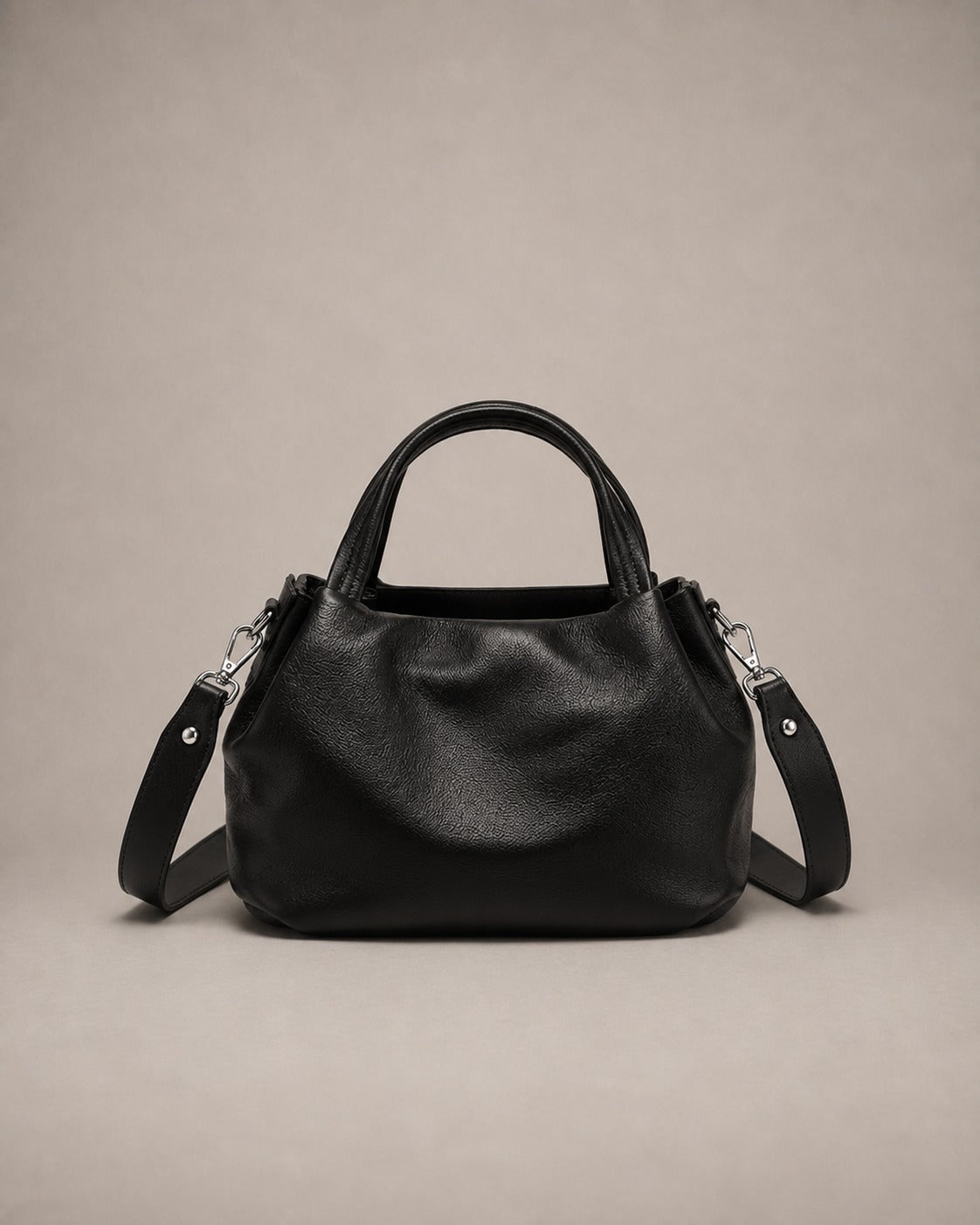 Front view of the Pauline genuine leather top handle crossbody bag in Black featuring soft pebbled leather, a structured silhouette and an adjustable shoulder strap by Malena London.