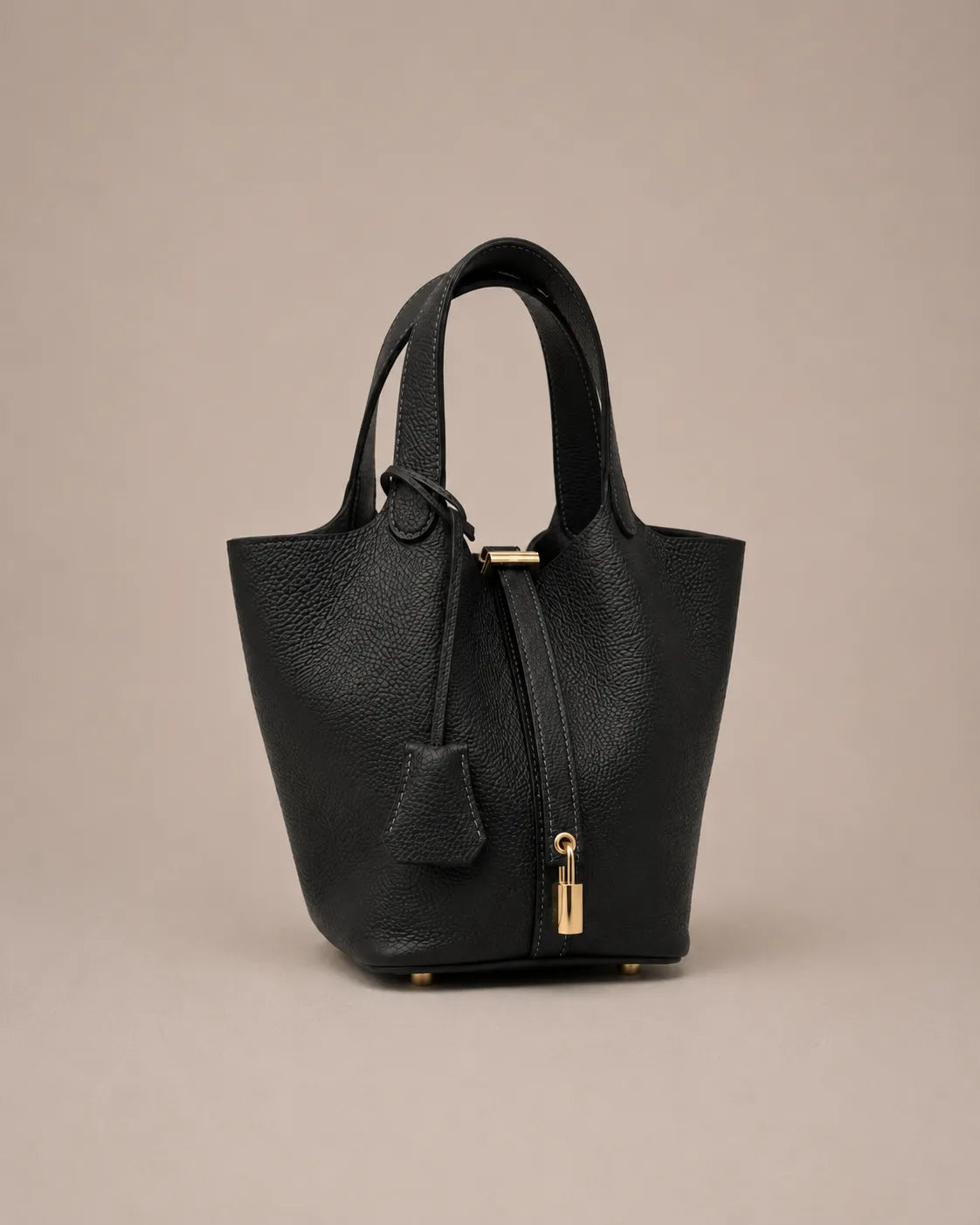 Angled front view of Scarlett genuine leather bucket tote bag in black leather with premium pebbled texture and lock closure