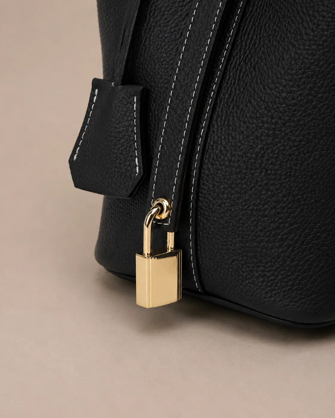 Close up detail of the Scarlett genuine leather bucket tote bag featuring premium lock hardware and pebbled leather texture
